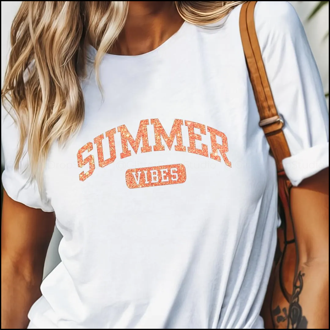 White t-shirt with 'Summer Vibes' text worn by a person, with a blurred background.